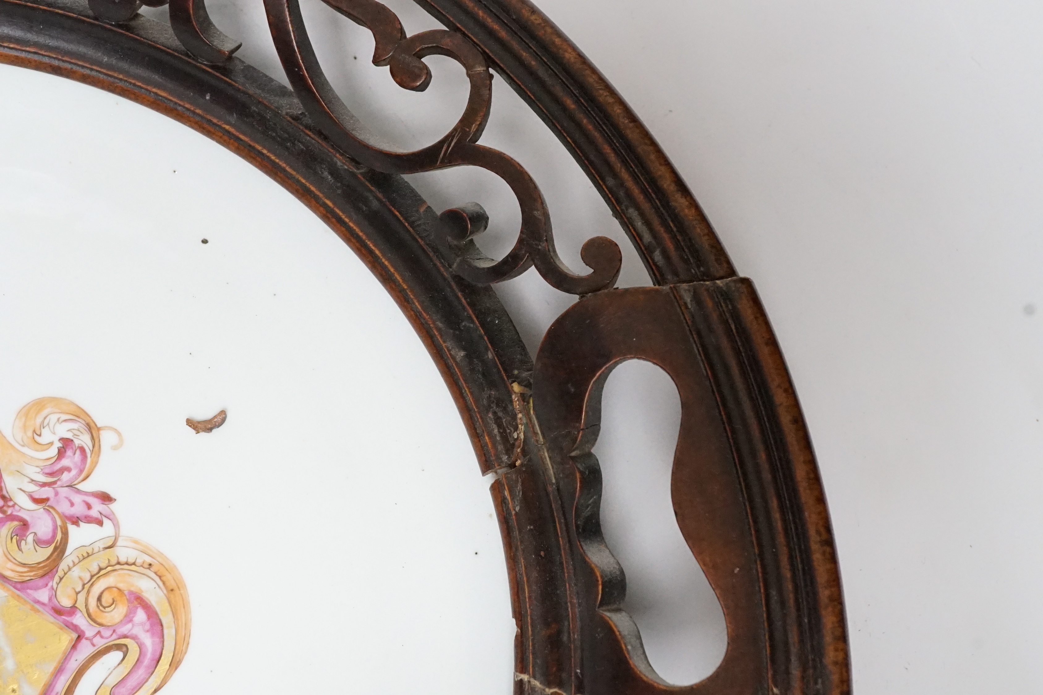 An 18th century Chinese armorial dish, rim cut down and mounted in a 19th century English mahogany frame, 39cm diameter